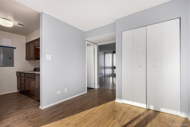 interior space featuring electric panel, visible vents, baseboards, and light wood-style flooring