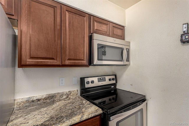 kitchen with a textured wall and stainless steel appliances