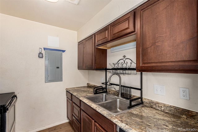 kitchen with baseboards, electric panel, a sink, dark brown cabinetry, and electric stove