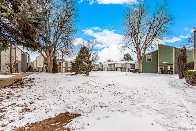 snowy yard featuring a residential view