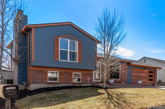 view of front of property featuring a garage, a front yard, brick siding, and a chimney