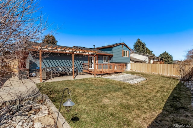 rear view of house featuring a yard, fence, and a wooden deck