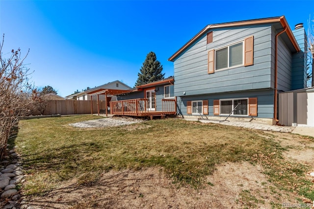 back of property with a deck, a storage shed, an outdoor structure, fence, and a lawn