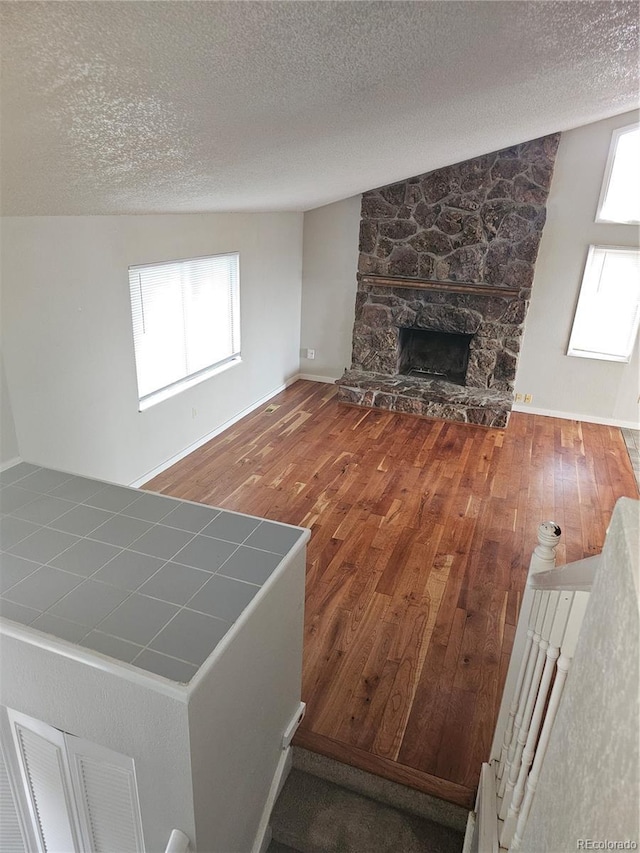 880 Orion Dr, Lafayette, CO 80026 - unfurnished living room with a textured ceiling, wood-type flooring, a fireplace, and baseboards