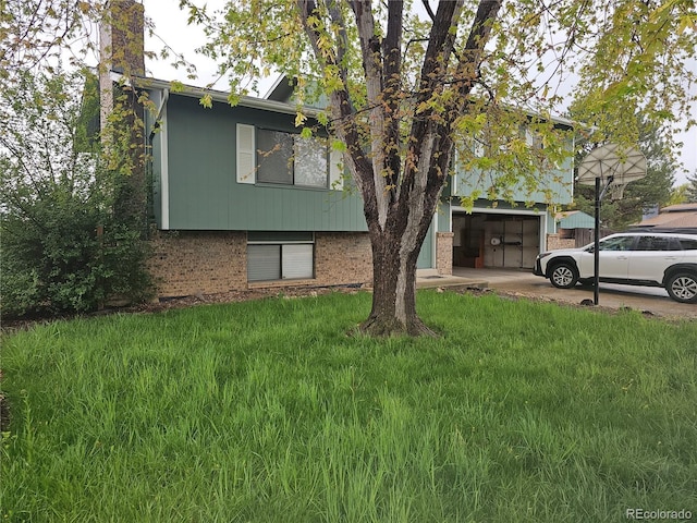 880 Orion Dr, Lafayette, CO 80026 - view of front facade with brick siding, an attached garage, concrete driveway, and a front yard