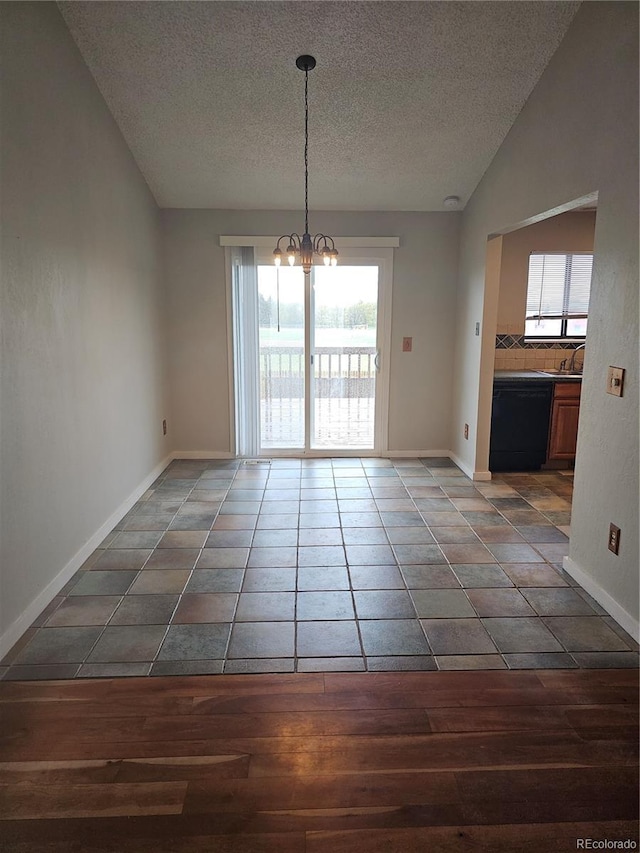 880 Orion Dr, Lafayette, CO 80026 - unfurnished dining area with a textured ceiling, wood finished floors, a chandelier, healthy amount of natural light, and baseboards