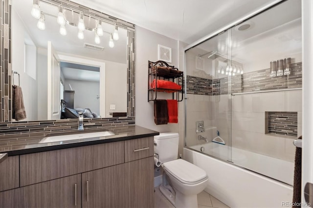 2898 W 22nd Ave, Denver, CO 80211 - full bath featuring toilet, vanity, decorative backsplash, bath / shower combo with glass door, and tile patterned floors