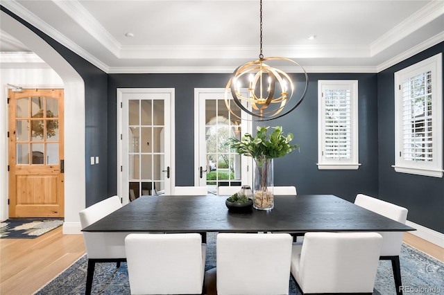 1164 S High St, Denver, CO 80210 - dining area featuring a chandelier, wood finished floors, arched walkways, plenty of natural light, and crown molding