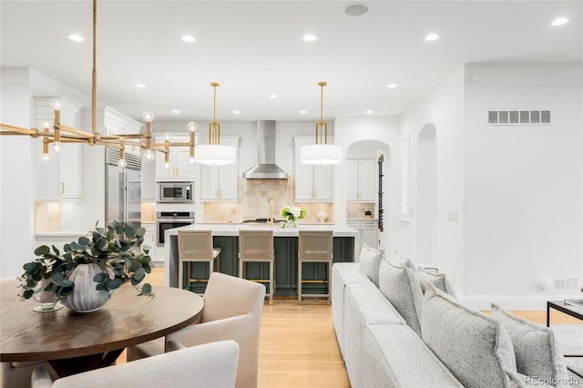 1164 S High St, Denver, CO 80210 - living room featuring arched walkways, light wood finished floors, and recessed lighting