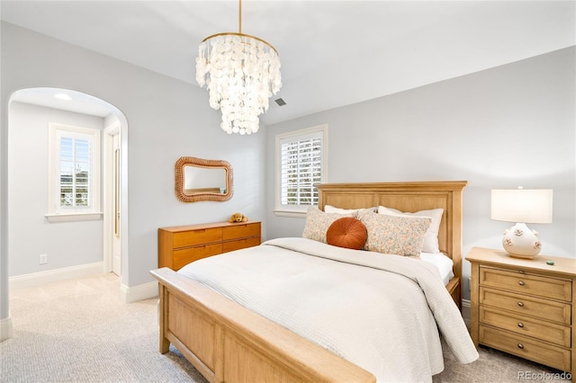 1164 S High St, Denver, CO 80210 - bedroom featuring arched walkways, a chandelier, and light colored carpet