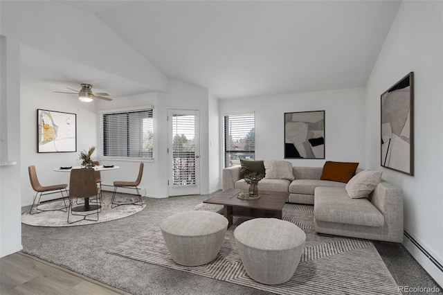 living area featuring vaulted ceiling, wood finished floors, baseboards, and a baseboard radiator