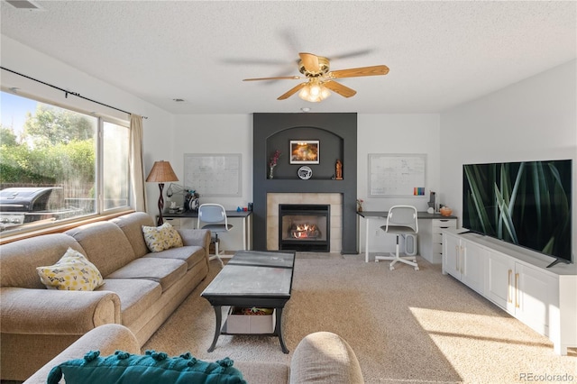 4363 E Andover Ave, Castle Rock, CO 80104 - living area featuring a textured ceiling, a tiled fireplace, ceiling fan, and light colored carpet