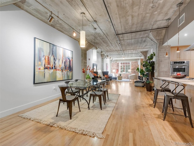 1449 Wynkoop St Unit 305, Denver, CO 80202 - dining space with light wood-type flooring, baseboards, and rail lighting