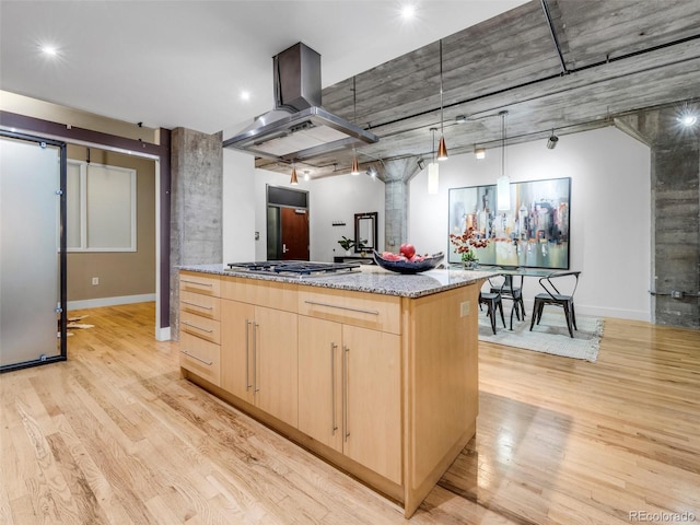1449 Wynkoop St Unit 305, Denver, CO 80202 - kitchen with light brown cabinets, island exhaust hood, light wood finished floors, baseboards, and light stone countertops