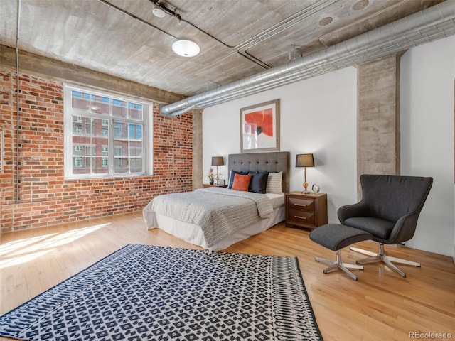 1449 Wynkoop St Unit 305, Denver, CO 80202 - bedroom with brick wall and wood finished floors