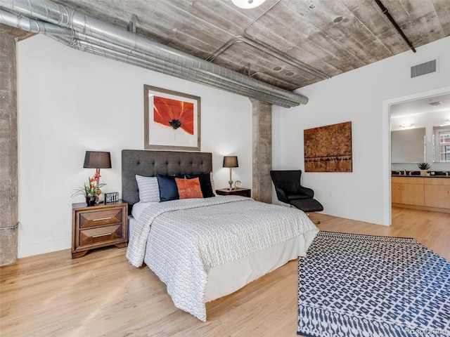 1449 Wynkoop St Unit 305, Denver, CO 80202 - bedroom with light wood-type flooring, decorative columns, and a sink