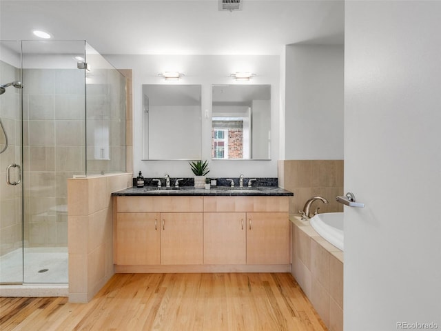 1449 Wynkoop St Unit 305, Denver, CO 80202 - bathroom with a shower stall, wood finished floors, double vanity, a garden tub, and recessed lighting
