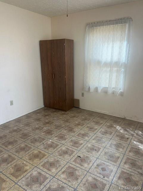 unfurnished room featuring a textured ceiling