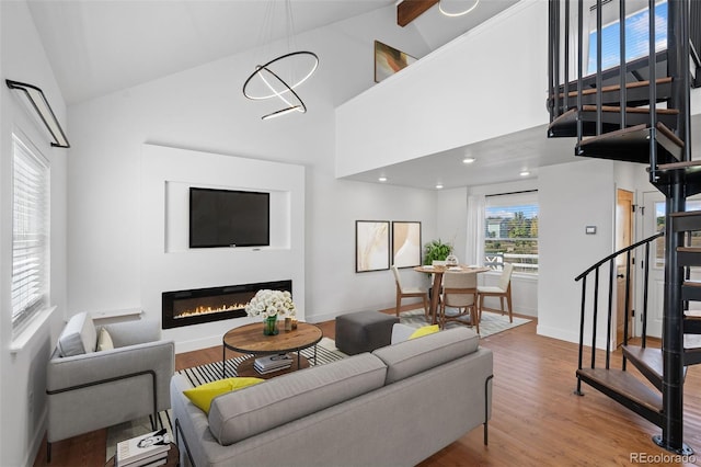 living room with hardwood / wood-style flooring, high vaulted ceiling, a chandelier, and beam ceiling