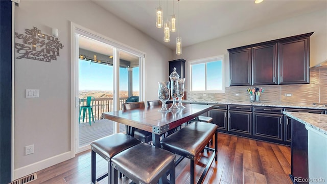 kitchen featuring a wealth of natural light, visible vents, decorative backsplash, and dark wood-style flooring