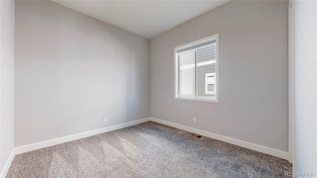 carpeted spare room with visible vents and baseboards