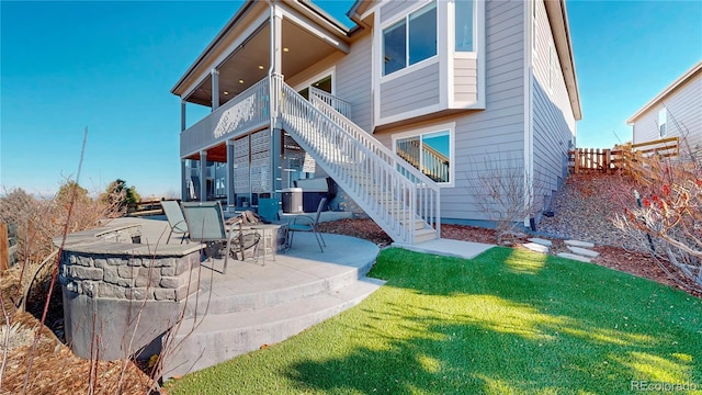 rear view of property with a yard, a patio, fence, and stairs