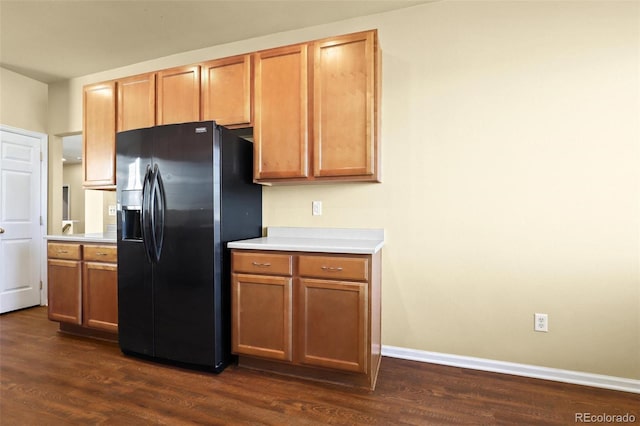 kitchen featuring baseboards, black refrigerator with ice dispenser, dark wood-type flooring, and light countertops