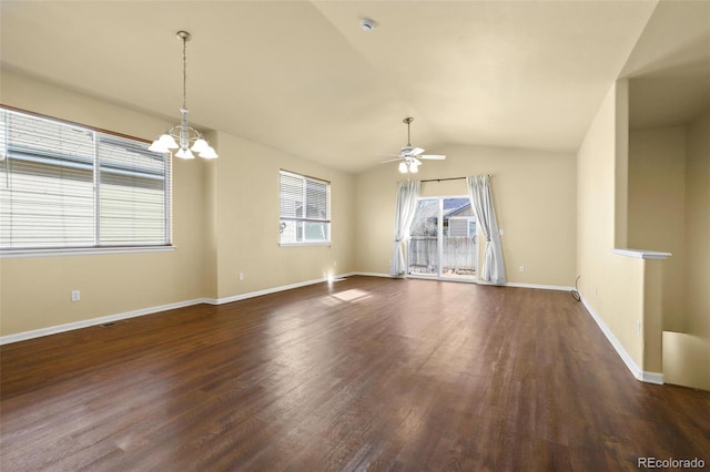 spare room with baseboards, vaulted ceiling, dark wood-style flooring, and ceiling fan with notable chandelier