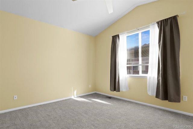 spare room featuring lofted ceiling, carpet floors, and baseboards