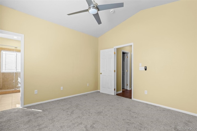 unfurnished bedroom featuring vaulted ceiling, carpet floors, connected bathroom, and baseboards