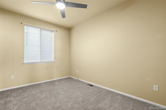 carpeted spare room featuring visible vents, baseboards, and a ceiling fan