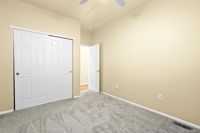 unfurnished bedroom with baseboards, carpet, visible vents, and attic access