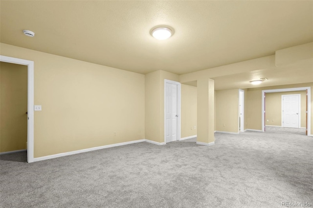 carpeted empty room featuring baseboards