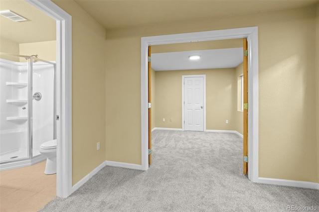 hallway featuring carpet floors, visible vents, and baseboards