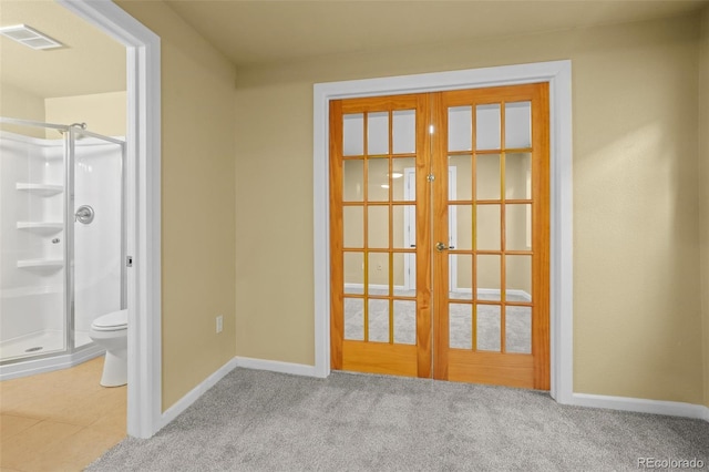 doorway to outside featuring visible vents, baseboards, carpet flooring, and french doors