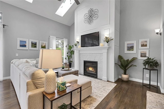 171 Columbine St, Larkspur, CO 80118 - living room featuring high vaulted ceiling, a skylight, a premium fireplace, dark wood-type flooring, and a ceiling fan