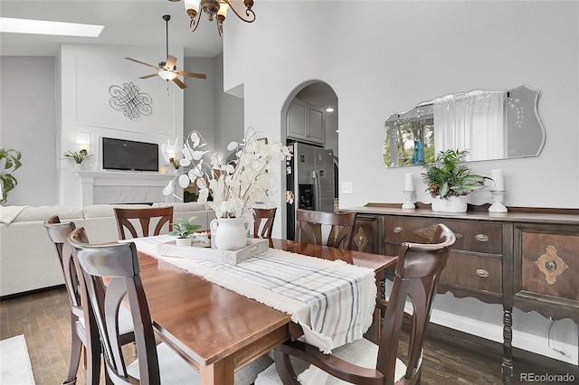 171 Columbine St, Larkspur, CO 80118 - dining room featuring a ceiling fan, wood finished floors, arched walkways, and a towering ceiling