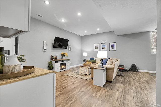 171 Columbine St, Larkspur, CO 80118 - living room with light wood finished floors, a lit fireplace, and recessed lighting