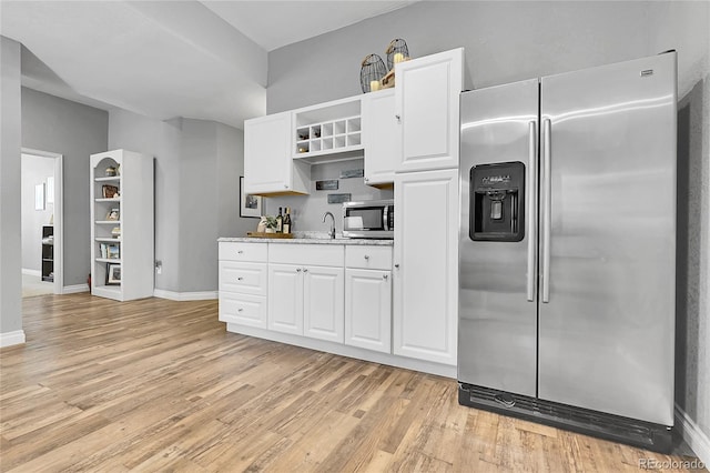 171 Columbine St, Larkspur, CO 80118 - kitchen with appliances with stainless steel finishes, light wood finished floors, open shelves, white cabinets, and light countertops