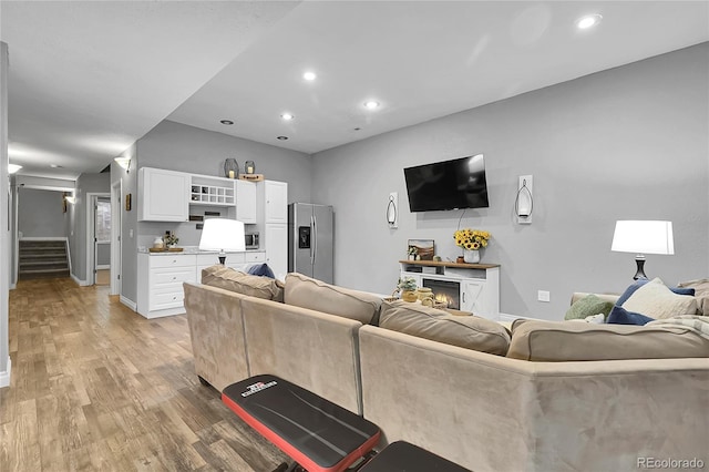171 Columbine St, Larkspur, CO 80118 - living area with stairway, light wood finished floors, recessed lighting, and a lit fireplace
