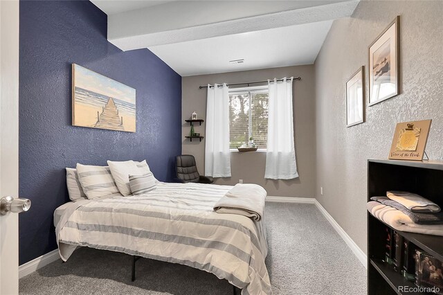 171 Columbine St, Larkspur, CO 80118 - carpeted bedroom with a textured wall and beam ceiling