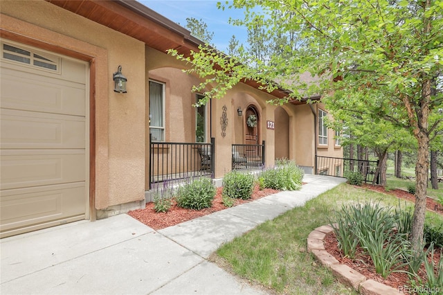 171 Columbine St, Larkspur, CO 80118 - property entrance with stucco siding, covered porch, and a garage