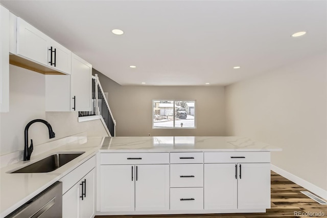 kitchen featuring sink, white cabinetry, dark hardwood / wood-style floors, stainless steel dishwasher, and kitchen peninsula