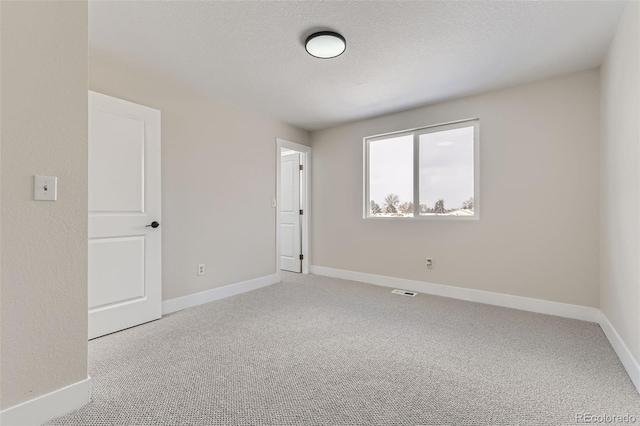 spare room featuring carpet and a textured ceiling