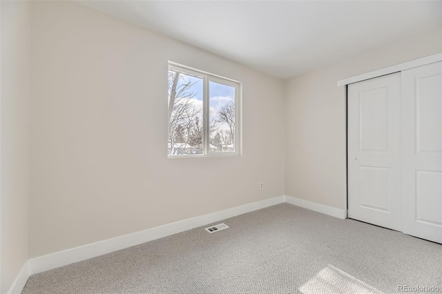 unfurnished bedroom featuring carpet flooring and a closet