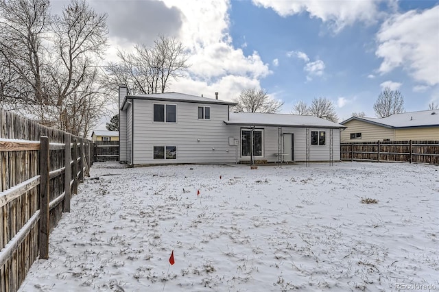 view of snow covered rear of property