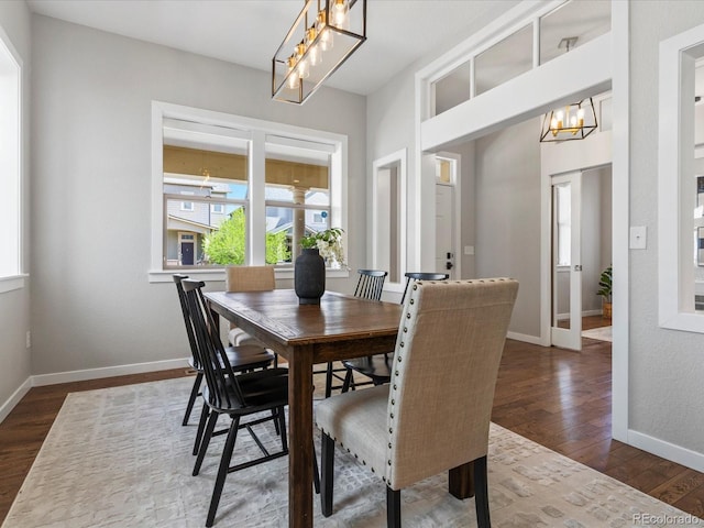 5511 Wabash St, Denver, CO 80238 - dining room featuring a chandelier, dark wood-style floors, and baseboards