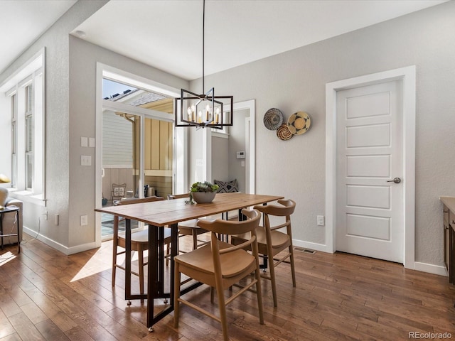 5511 Wabash St, Denver, CO 80238 - dining room featuring dark wood-style flooring, healthy amount of natural light, baseboards, and a chandelier