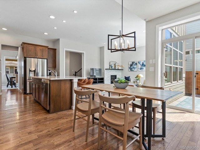 5511 Wabash St, Denver, CO 80238 - dining room with hardwood / wood-style flooring, recessed lighting, a chandelier, a glass covered fireplace, and stairway