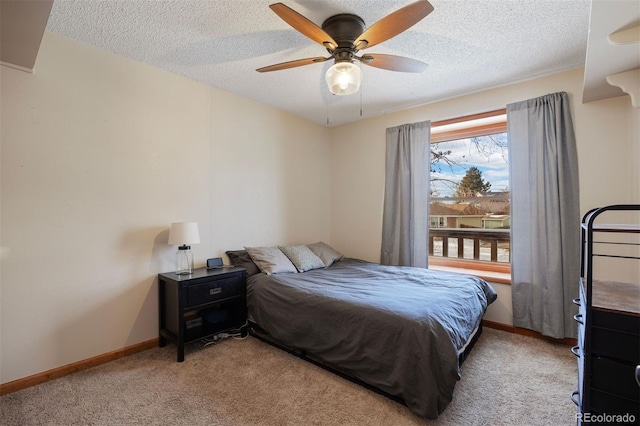 bedroom with a textured ceiling, ceiling fan, and light carpet